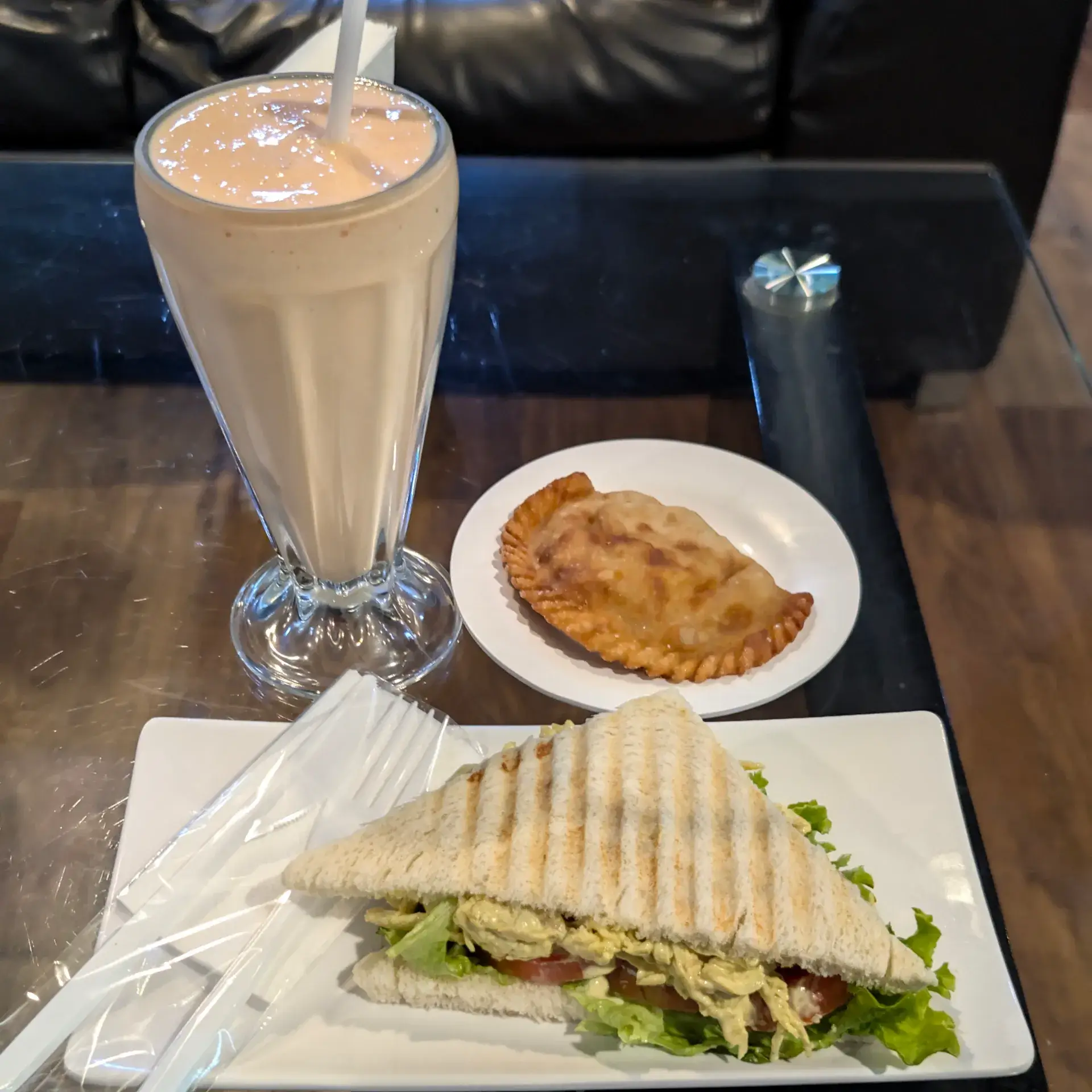 空港ラウンジでいただいた軽食セット。サンドイッチ、エンパナーダ、そしてスムージーの贅沢な休憩メニューです。