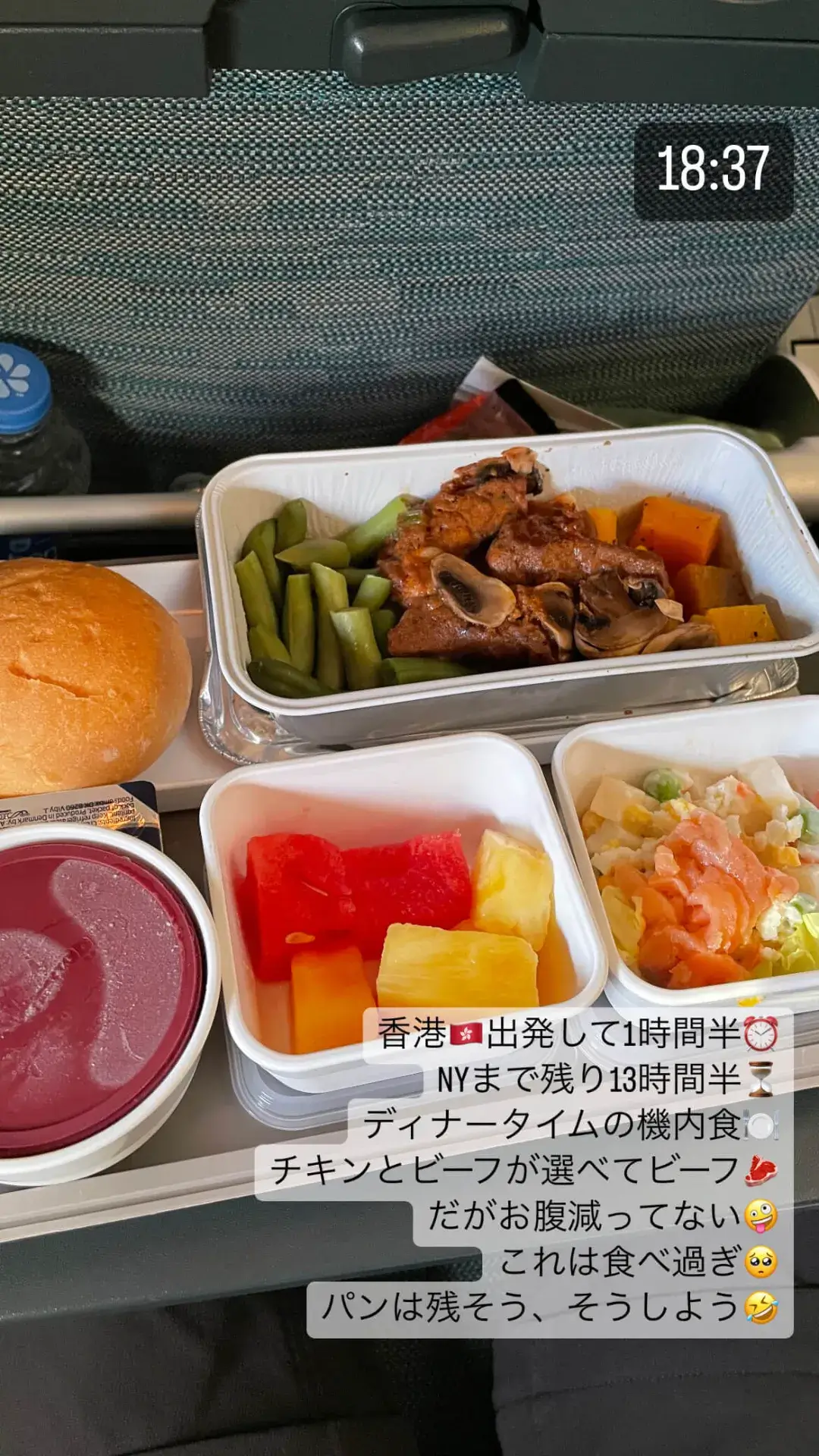 ニューヨークへの長距離フライト中、座席でリラックスしながら楽しむ水とミニプレッツェルの軽食です。