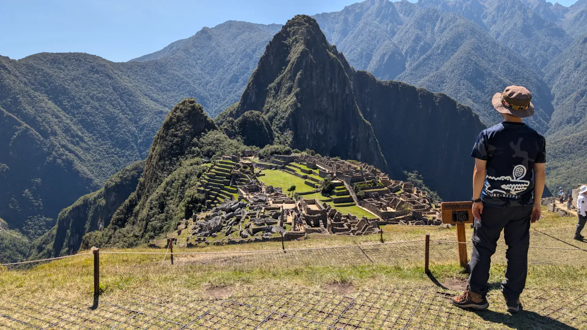 マチュピチュ山の長い下り坂を経て、遺跡を最も美しく見渡せる「見張り小屋」付近のテラスへ。目の前には、ワイナピチュ山の険しい峰と、その懐に抱かれた石造りの都市が、完璧な調和をもって広がっています。かつてインカの人々も同じようにこの山々を仰ぎ、自然への祈りを捧げたであろうその場所に立ち、静かに遺跡を見つめるひととき。山頂からの興奮が静かな感動へと変わり、この壮大な文明が歩んできた永い時間の中に身を置いているような、深い充足感に満たされる旅の終盤シーンです。