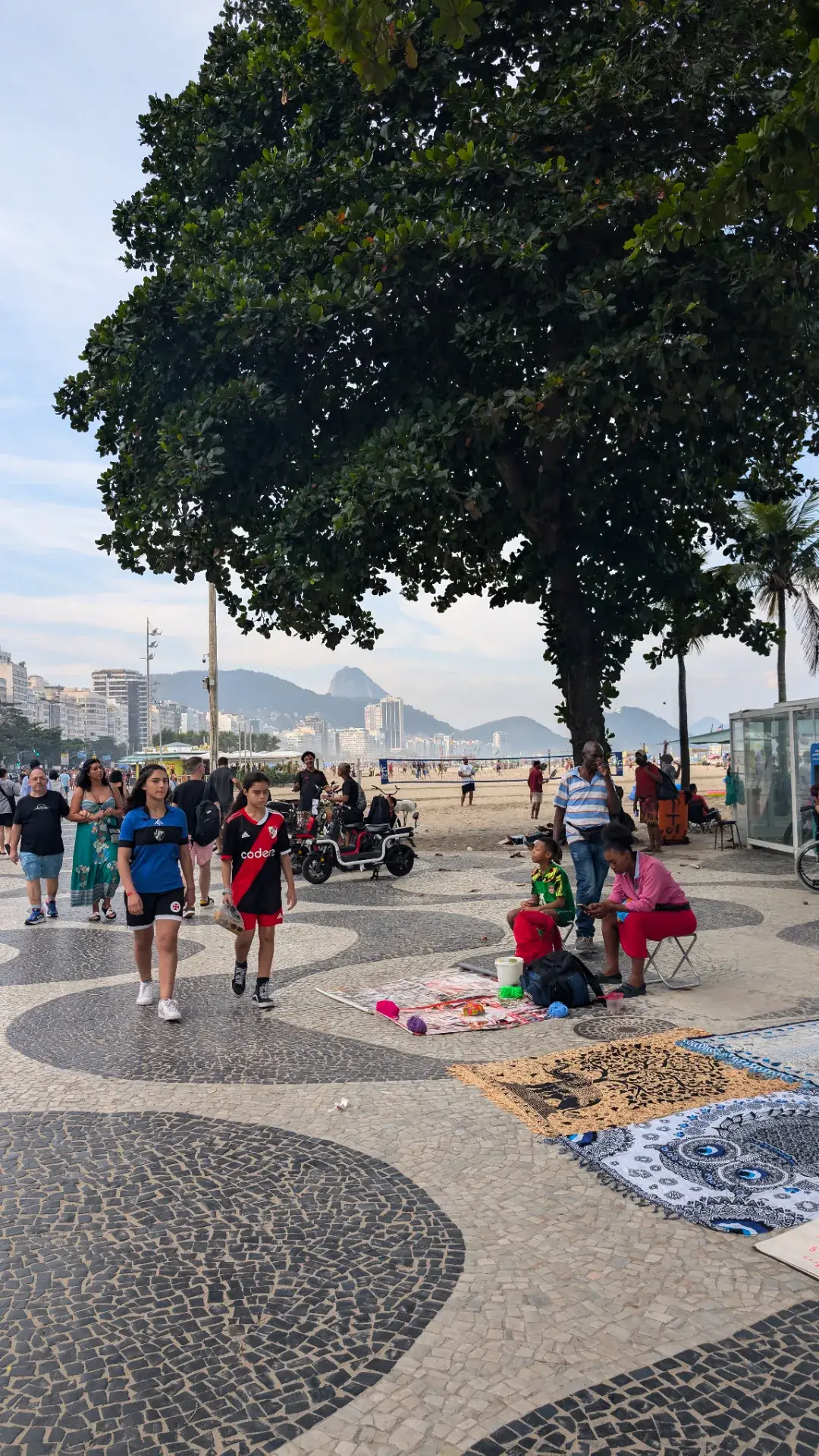 ブラジルのコパカバーナビーチ沿いの遊歩道です。有名なモザイク模様の歩道と、多くの人が行き交うビーチサイドの活気ある風景です。