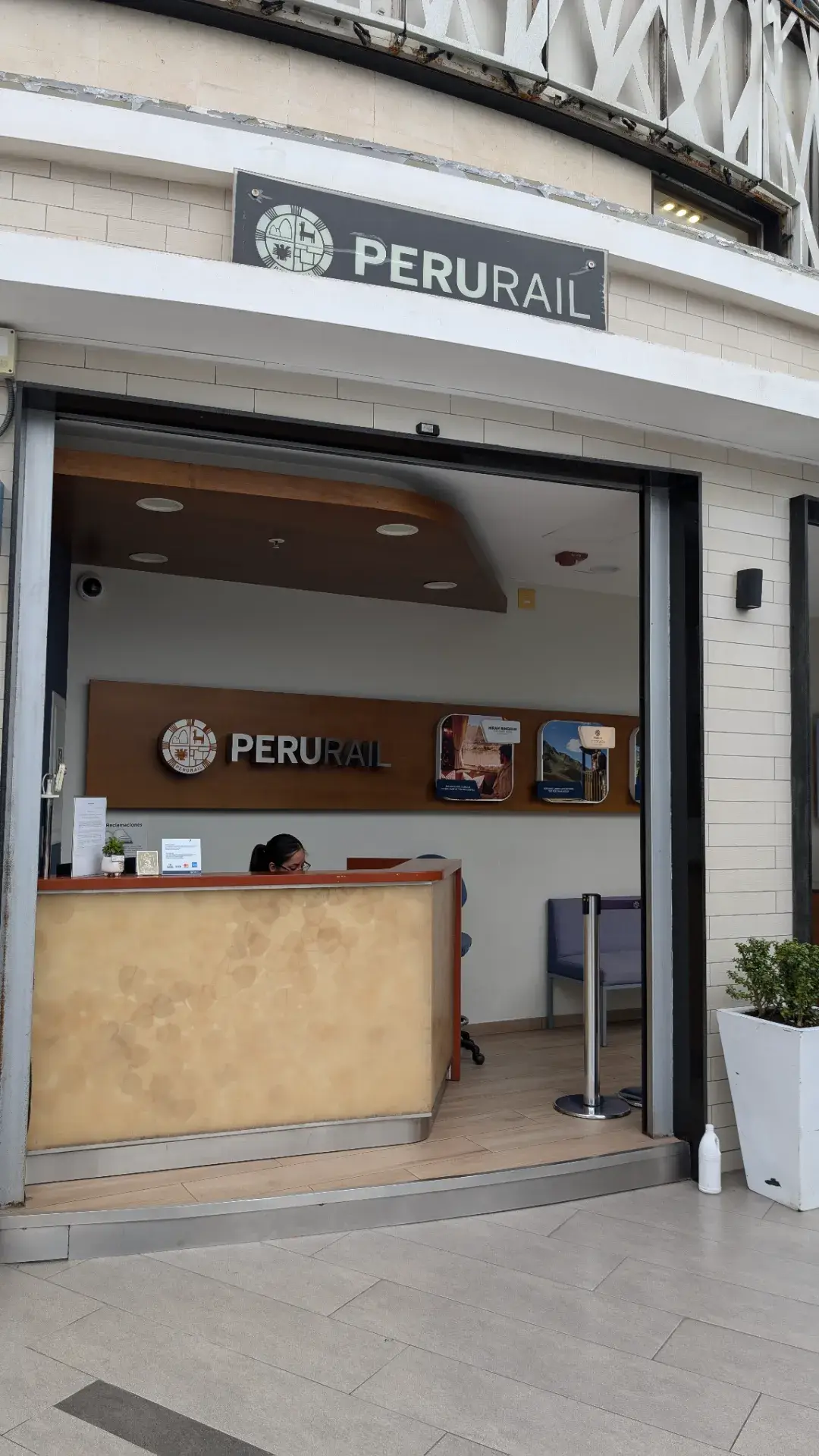 リマの街角にある「ペルーレイル(PeruRail)」のサービスセンター。世界遺産マチュピチュへと続く列車のチケット手配や情報提供を行う、旅の重要拠点です。洗練された木目調のカウンターの奥には、豪華列車「ハイラム・ビンガム」号などのパネルが飾られ、これから始まるアンデス山脈への冒険への期待を膨らませてくれます。インカのシンボルをあしらったロゴマークが、南米の歴史とモダンな旅のスタイルを象徴する一枚です。