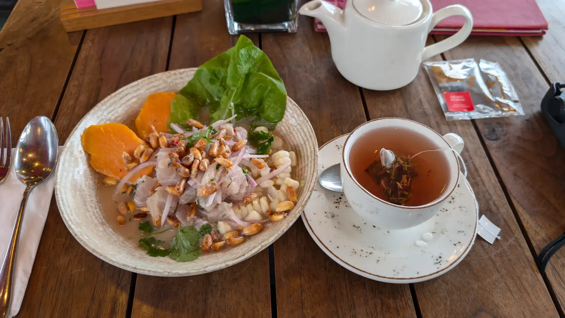 ペルー料理の代名詞とも言える「セビーチェ」。新鮮な白身魚のマリネを中心に、香ばしく揚げたトウモロコシ(カンチャ)、大粒の茹でトウモロコシ(チョクロ)、そして甘いサツマイモ(カモテ)が美しく盛り付けられています。添えられた温かい紅茶とともに、南米ならではの酸味と辛味の絶妙なハーモニーを堪能。