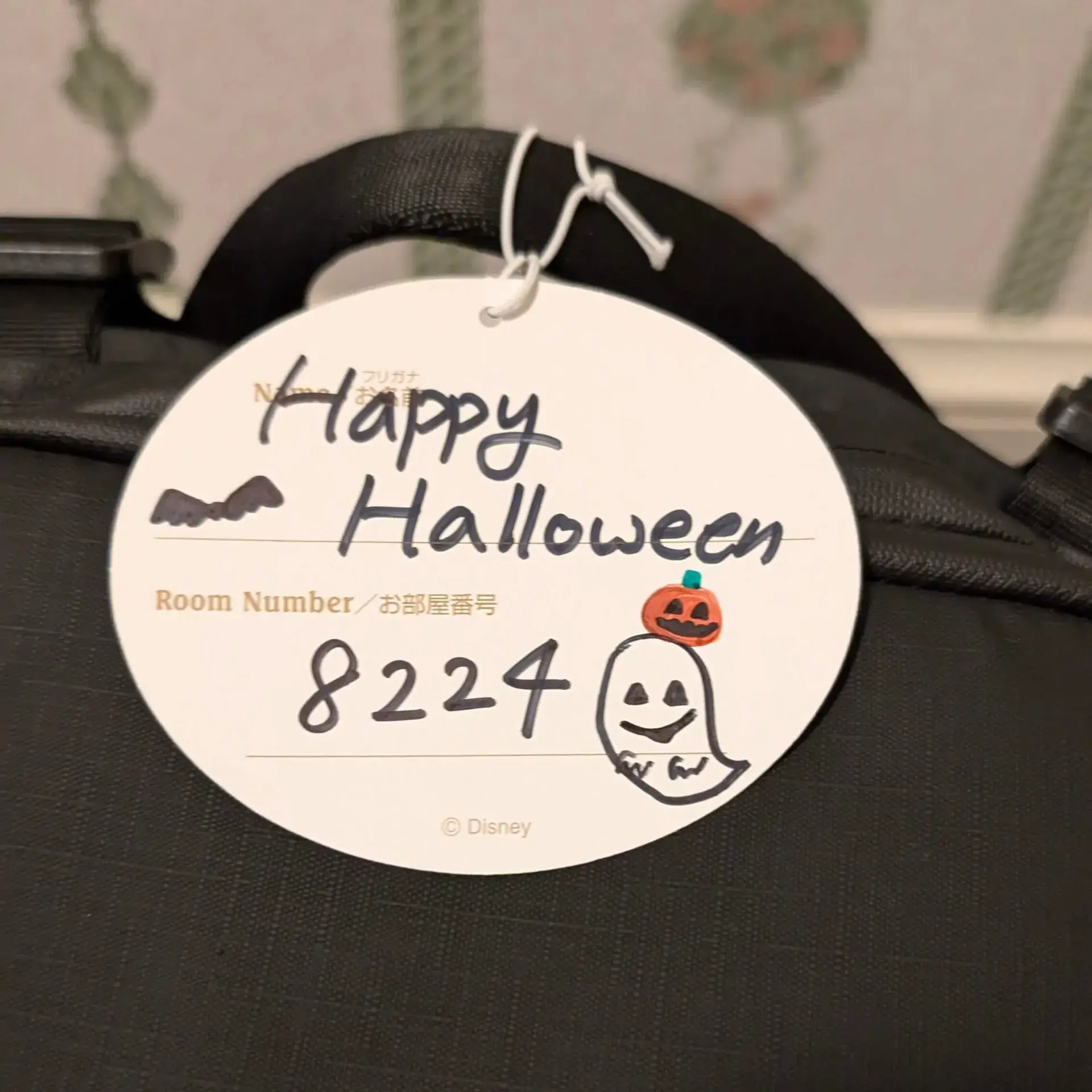 東京ディズニーランドホテルにて、チェックイン前に預けた荷物をお部屋まで届けてもらった際に付けられていたメッセージタグ。手書きの「Happy Halloween」という文字と、可愛らしいおばけ（ゴースト）のイラストが描かれた心温まるおもてなしの記録。