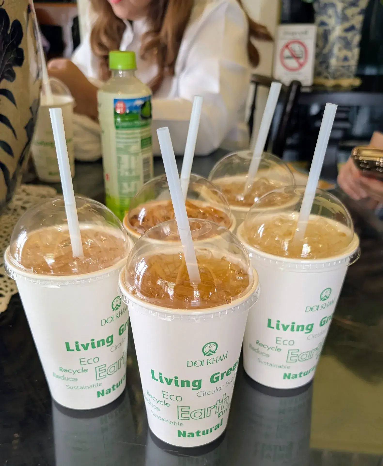 ワット・プラケオの見学中に立ち寄った、タイ王室プロジェクトが手がけるショップ「DOI KHAM（ドイカム）」のアイスドリンク。環境に配慮した「Living Green」のメッセージ入りカップには、たっぷりの氷と冷たいお茶（またはハーブティー）が入っています。広大な王宮敷地内を歩いた後の火照った体に、冷たい飲み物と冷房の効いた空間が心地よい、休息のひとときです。