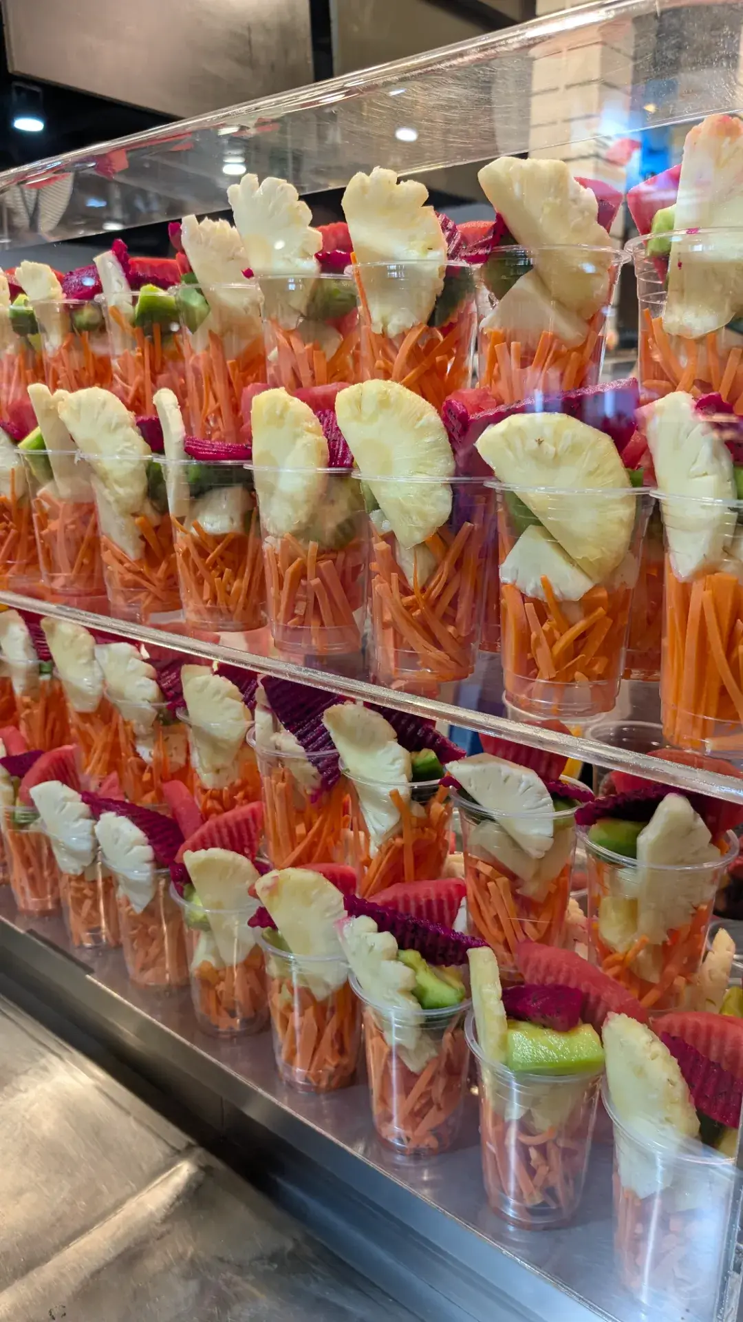 「PIER 21」フードコート内で目を引く、色鮮やかなカットフルーツのディスプレイ。パイナップル、スイカ、ドラゴンフルーツ、マンゴーなどがカップに美しくセットされており、好みのカップを選ぶとその場で氷と一緒にミキサーにかけて濃厚なシェイクにしてくれます。1杯30〜40バーツ前後という驚きの安さで、南国タイならではの贅沢なビタミン補給が楽しめる、食後のデザートに欠かせないスポットです。