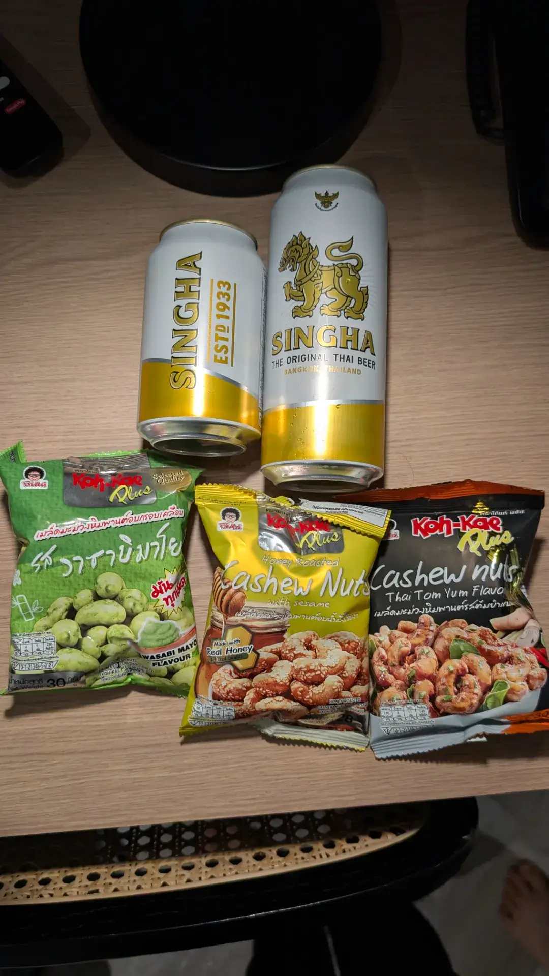 タイ旅行の夜を楽しむ晩酌セット。定番の「シンハービール（SINGHA）」と、人気のおつまみ「コーゲー（Koh-Kae）」のカシューナッツ。わさびマヨ、ハニーロースト、トムヤムクンの3種類のフレーバーが揃った、タイならではの至福のひとときです。