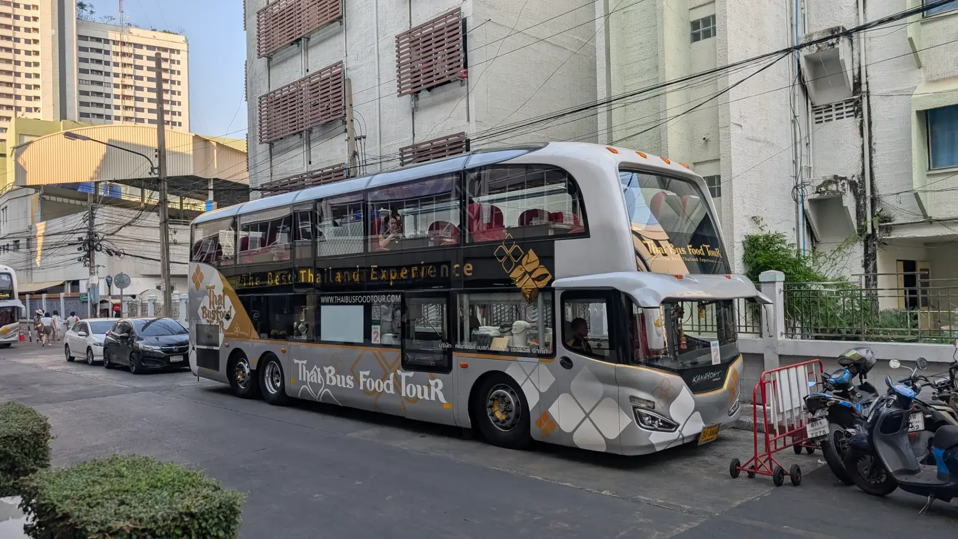バンコクの名所を巡りながら本格的なタイ料理を堪能できる、ラグジュアリーな2階建て観光バス「タイ・バス・フードツアー」。白とシルバーを基調とした車体には黄金の装飾が施され、大きなガラス窓からは街の景色を一望できます。ミシュラン掲載店の料理などが提供されることでも知られ、快適な車内で観光とグルメを同時に楽しめる、バンコクの新しいハイライトとして人気のツアーです。