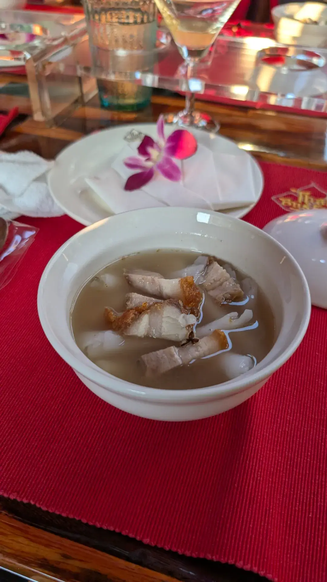 「タイ・バス・フードツアー」のコース料理として提供された、ヤワラートの名店「ナイ・エック・ロールヌードル」のクワイジャップ。くるりと丸まった独特のロール麺に、カリカリに揚げられたクリスピーポークがトッピングされています。胡椒がピリリと効いた透明感のあるスープは、バスの心地よい揺れとともに味わうことで、さらに特別な記憶として刻まれます。名店の行列に並ぶことなく、快適な車内でその至高の味を堪能できる、ツアー最大の醍醐味の一つです。