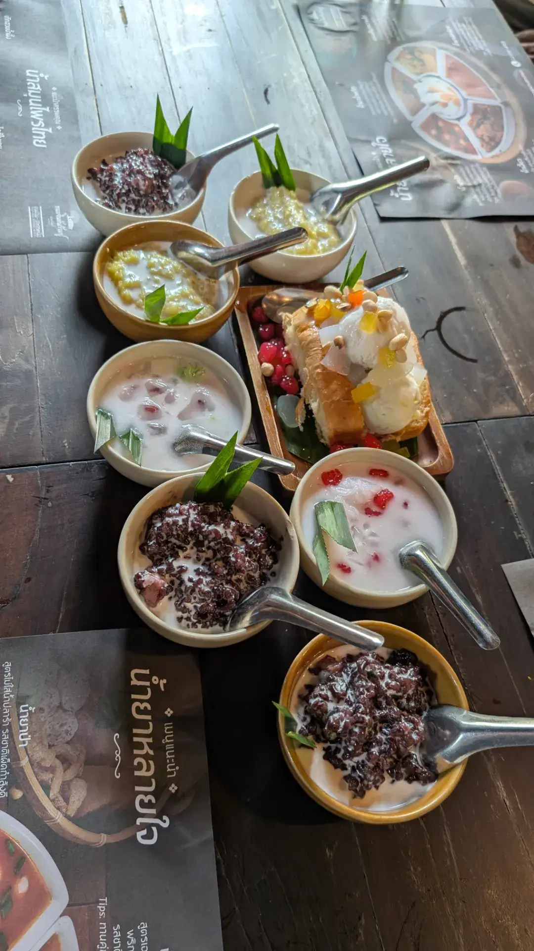 タイの伝統的なスイーツの盛り合わせ。黒米のココナッツミルクがけや、トーストにココナッツアイスを添えた「カノムパン・アイティム」など、食後のひとときを彩るバラエティ豊かなタイデザートのセットです。