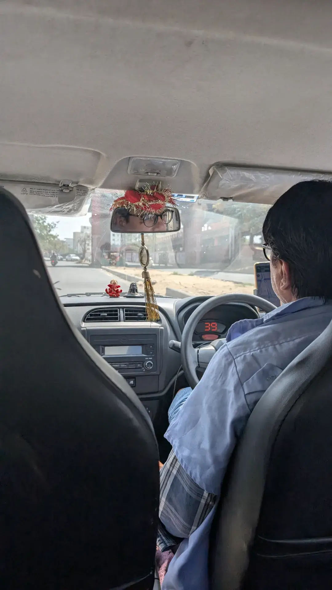 タクシーの車内から見たジャイプールの道路と、バックミラーに映るドライバーの様子