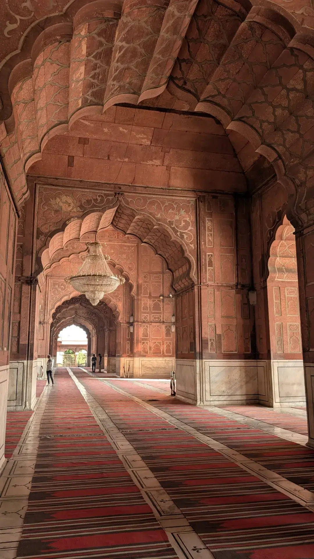 デリーのジャマー・マスジッド内部にある、美しい彫刻が施されたアーチと豪華なシャンデリア