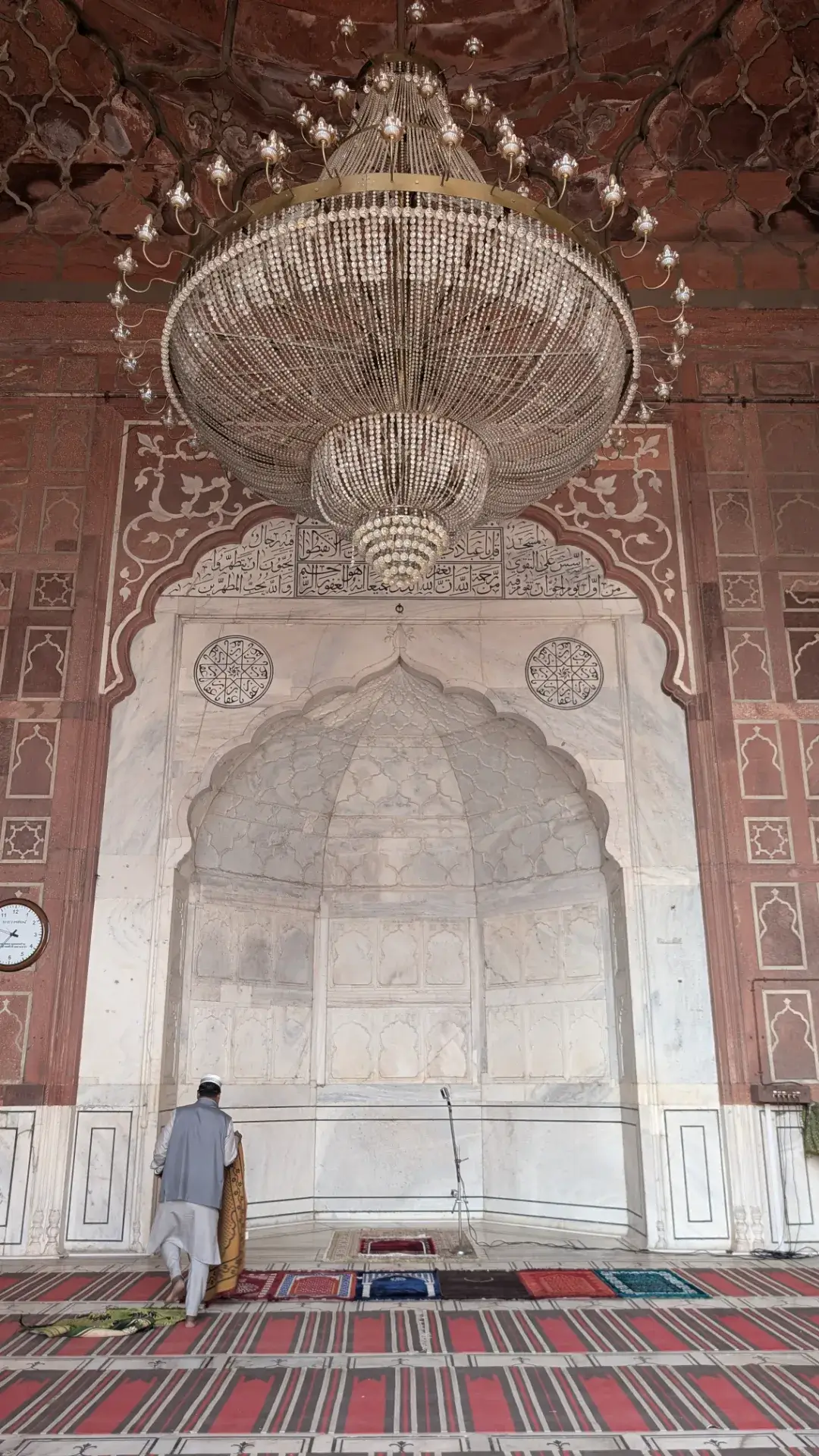 ジャマー・マスジッド内部の壮大なシャンデリアと礼拝の様子