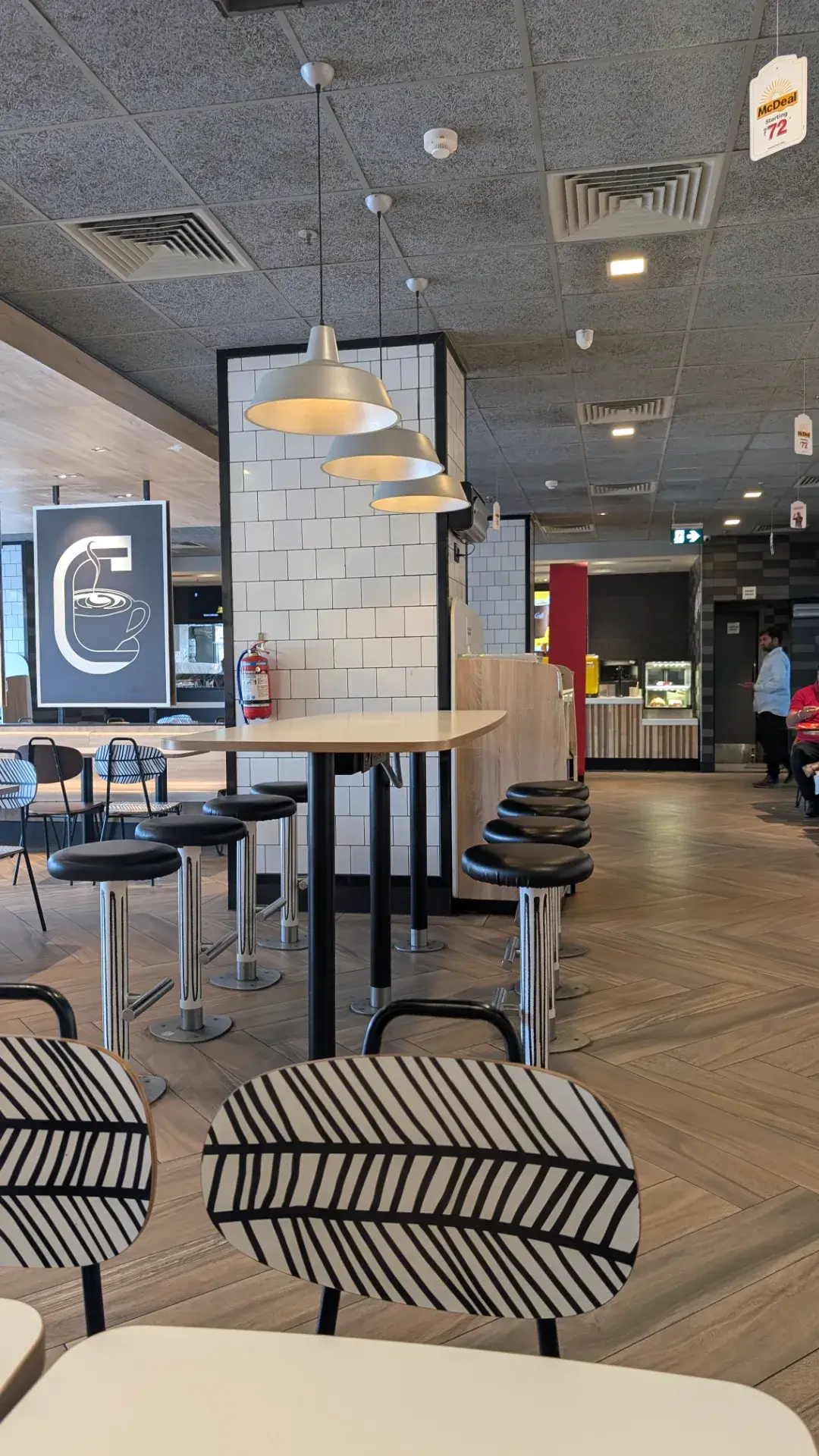 モダンスタイルの照明とテーブルが設置された、ジャイプール市内のカフェ店内風景。