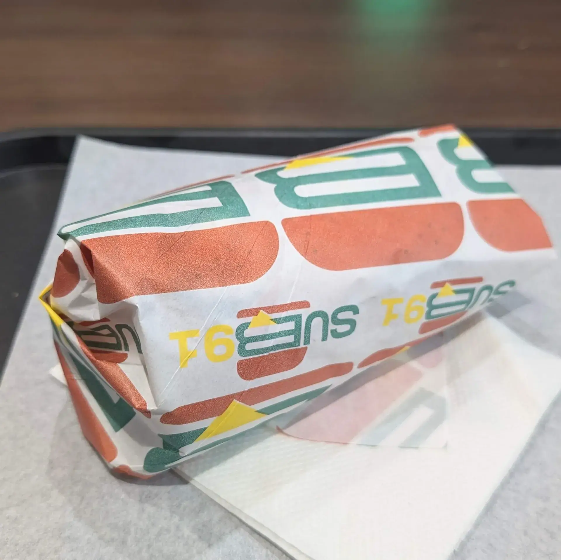 「SUB91」のロゴがデザインされた包装紙で包まれたサンドイッチ