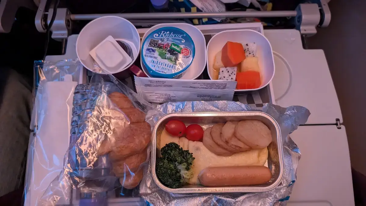 タイ国際航空の機内食（朝食）。メインのオムレツとソーセージ、フルーツ、ヨーグルトが揃ったセット。