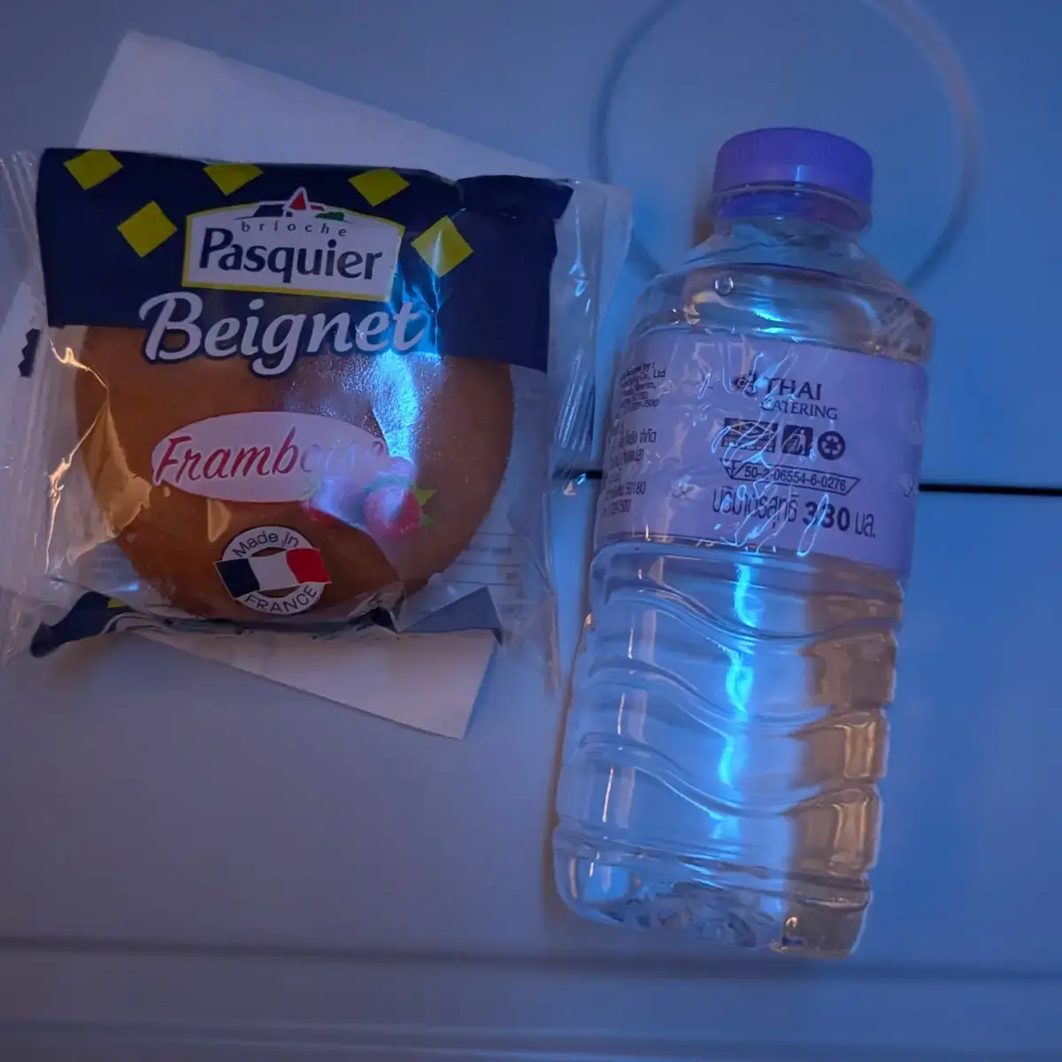 タイ国際航空（THAI Catering）の機内食。パスキエのラズベリーベニエとミネラルウォーター。