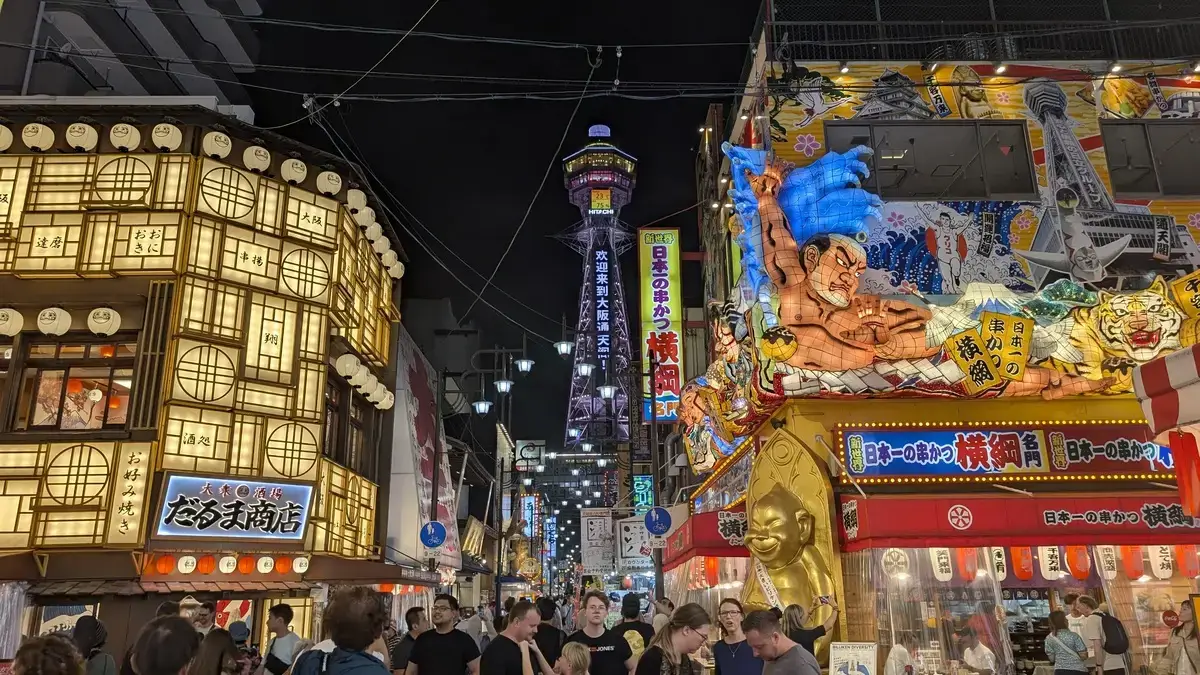 大阪・新世界のド派手な夜景。串かつ横綱やだるま商店の巨大看板と通天閣。