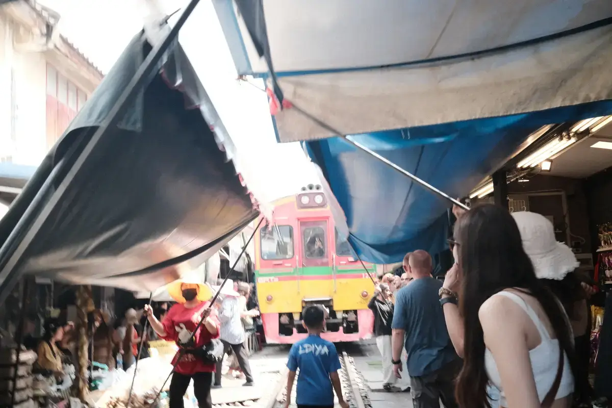 メークロン鉄道市場の最大の特徴である、列車の通過に合わせて商店が日除け（オーニング）を畳み、支柱で支えている様子