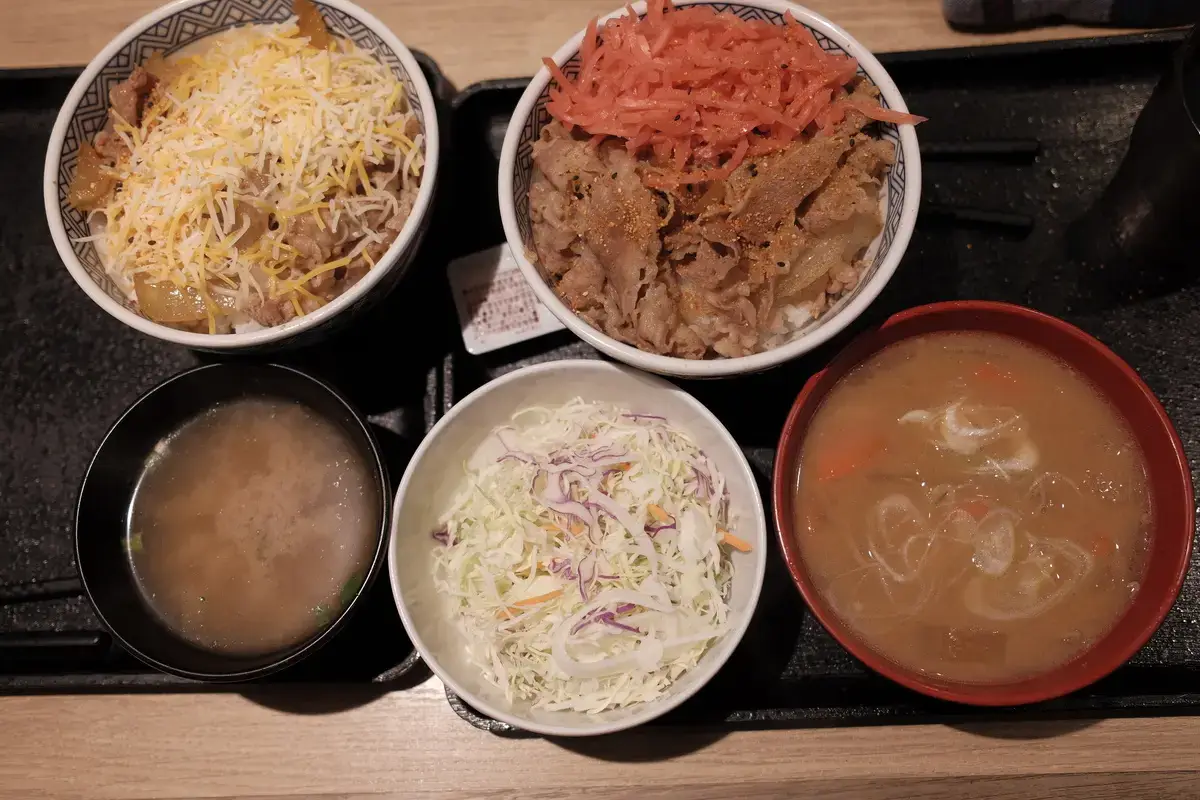 吉野家（Yoshinoya）の定番ランチの写真。牛丼、チーズ牛丼、紅生姜、味噌汁、豚汁