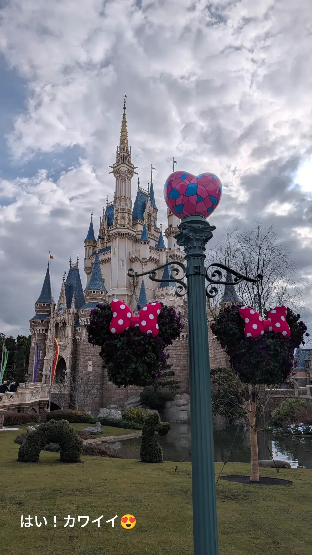 ミニーのファンダーランド開催中の東京ディズニーランドで、ミニーマウスの形をしたハンギングバスケットとシンデレラ城