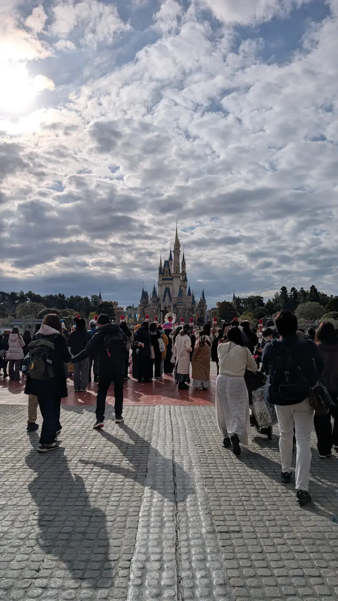 東京ディズニーランドのワールドバザールを抜けてシンデレラ城へと続くプラザの道と冬の装いのゲストたち