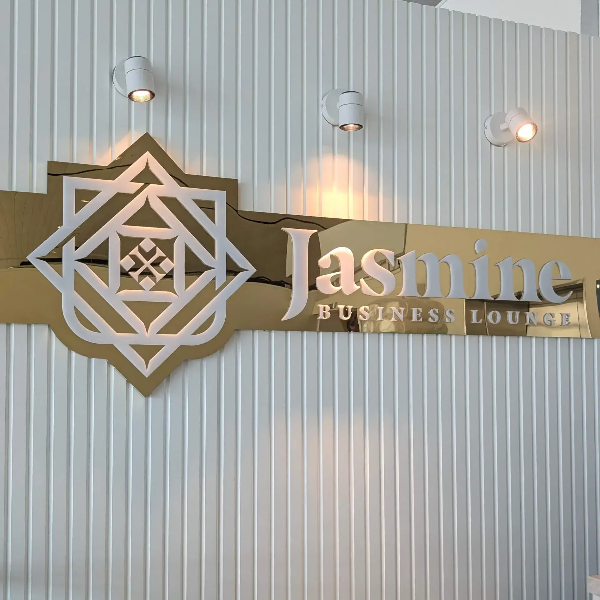 「Jasmine Business Lounge」の金色の立体看板と照明
