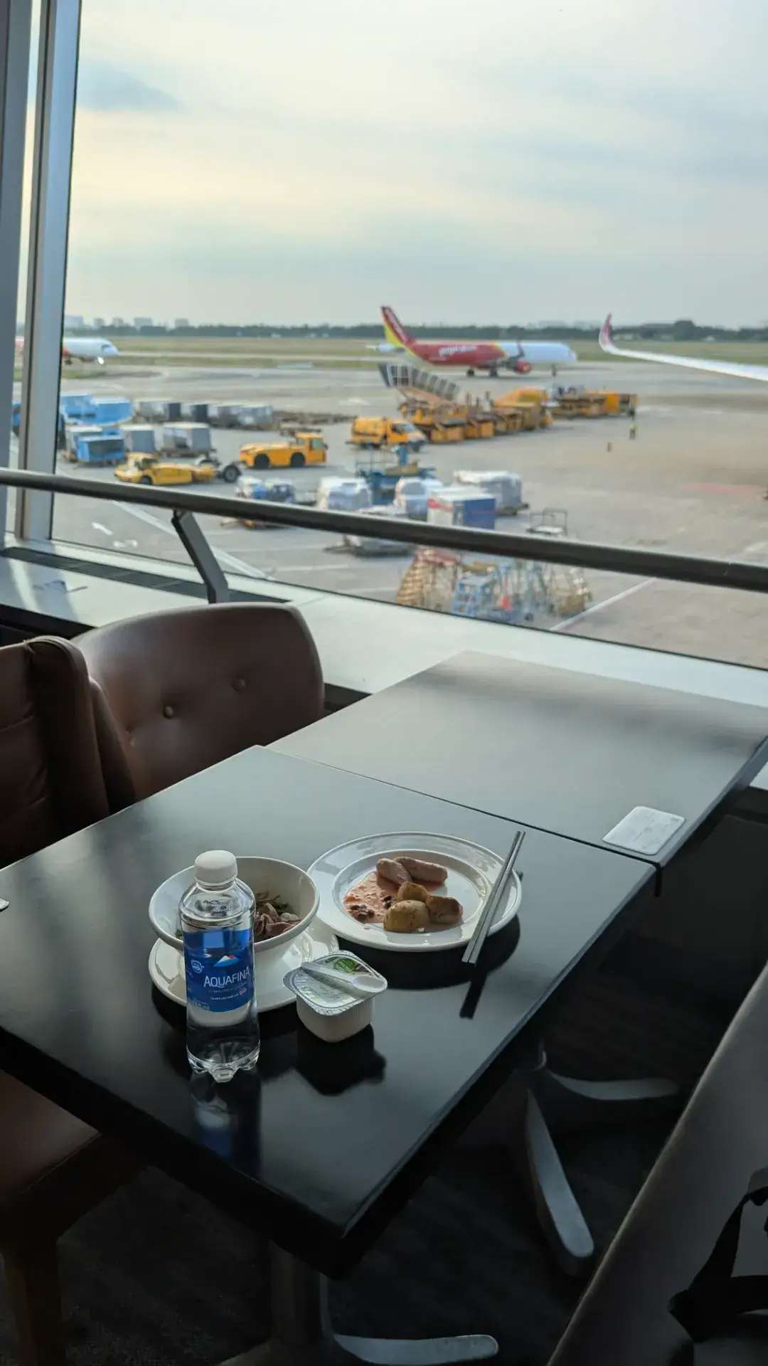ビジネスラウンジの窓から見える空港の駐機場と食事の様子